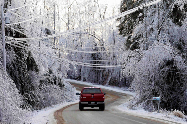 A truck heads down a road lined with ice-covered trees in North Berwick, Maine, on Sunday, Dec. 14, 2008. 